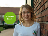 Portrait von Rebecca Huhmann. Ein Sticker sagt aus: 1 ATF-Stunde