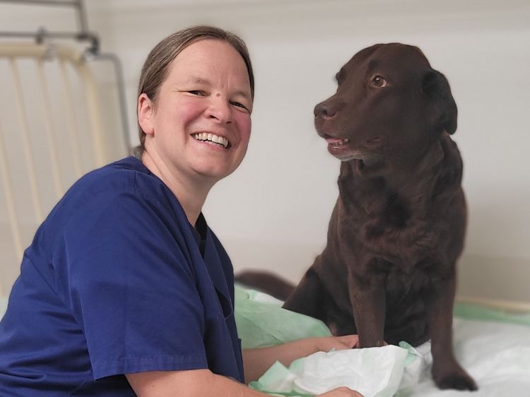 Portrait von Esther Haßdenteufel mit braunem Labrador